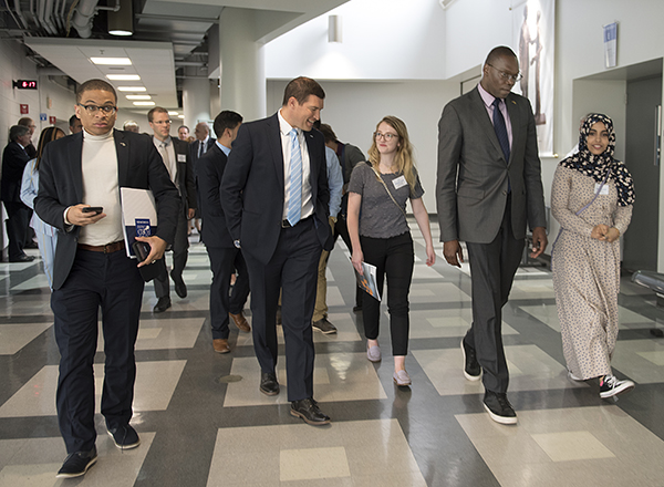 President Kavalhuna, Lt. Gov. Garlin Gilchrist, students and dignitaries walk to a robotics lab.