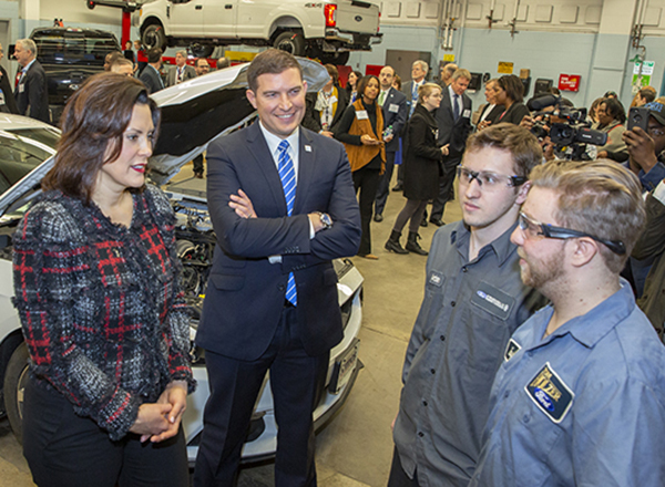 Governor Whitmer, President Kavalhuna, two students in auto lab