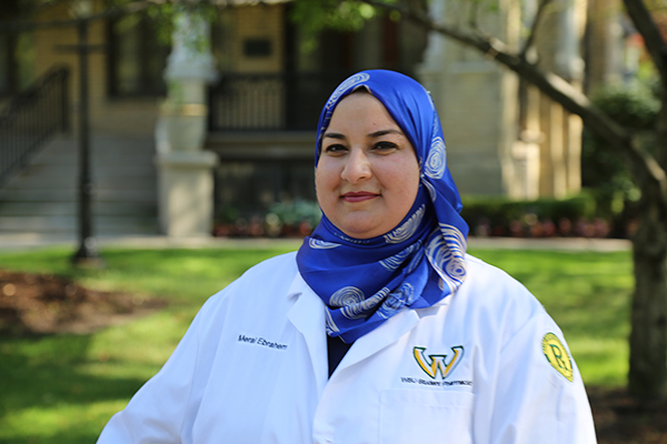 Portrait of Meral Ebrahem wearing a white lab coat, smiling.