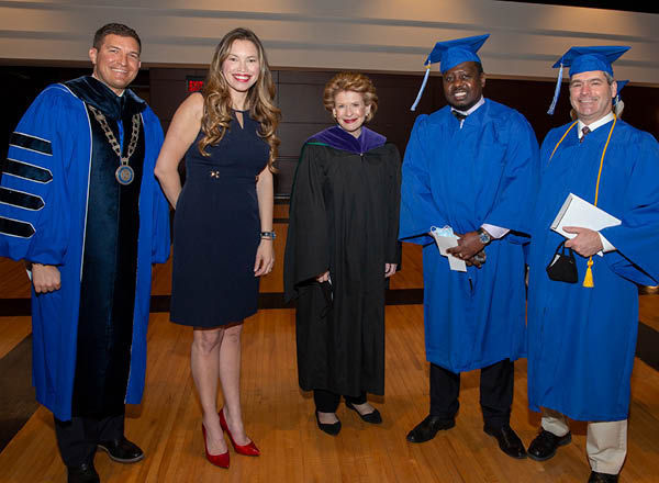 HFC President Russ Kavalhuna, left, with Trustee Irene Watts, Senator Debbie Stabenow, and graduates.