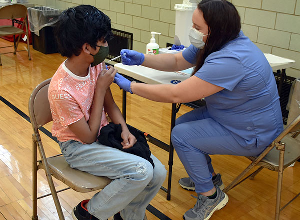 An image of a nurse administering the vaccine to a student at the vaccine clinic.