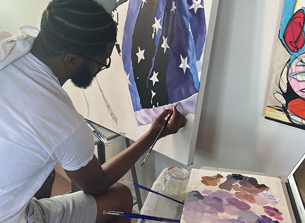 Artist Jonathan Harris puts the finishing touches on one of his paintings. 