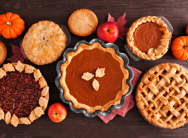 A photo of several pies and fruits.