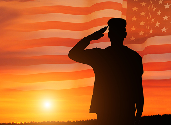 Silhouette of veteran saluting American Flag
