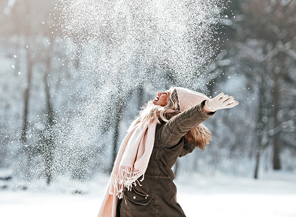 Image of person happily throwing snow into the air