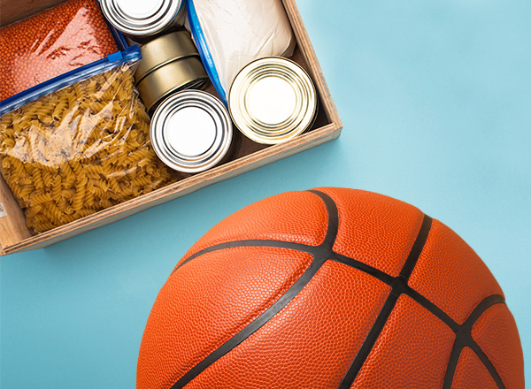 A basketball next to a box of non-perishable goods.