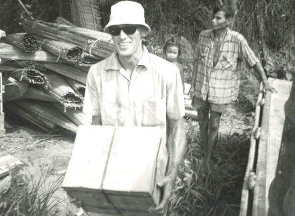 In a photo dated April 18, 1967, Retired HFC English instructor Ed Demerly carries a box of cottonseed oil during his time in the Peace Corps. 