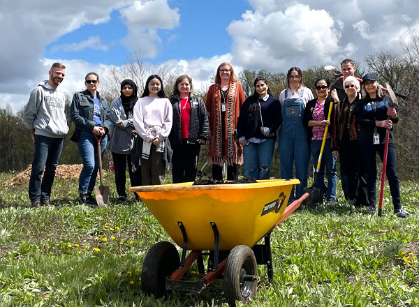 Sustainable HFC committee members lined up behind a yellow wheelbarrow.
