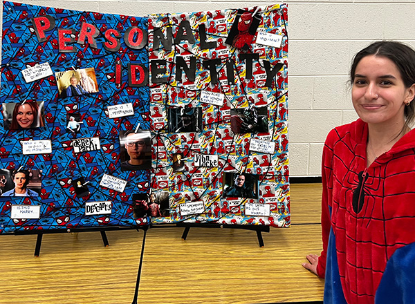 Savanna Vela (in Spider-Man costume) in front of poster of her presentation