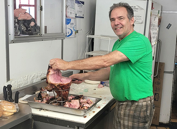 Harry Lile carves ham at Lile's Sandwich Shop in Dearborn. 