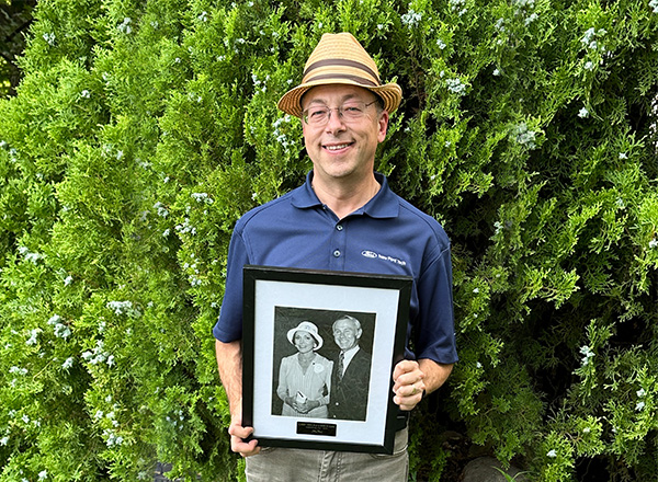 Portrait of photographer Lance Rosol holding a vintage photo.