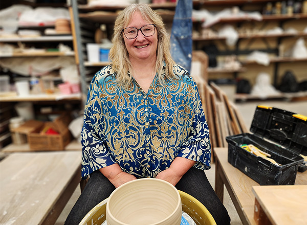 Patty Goodall at her pottery wheel with a clay bowl.