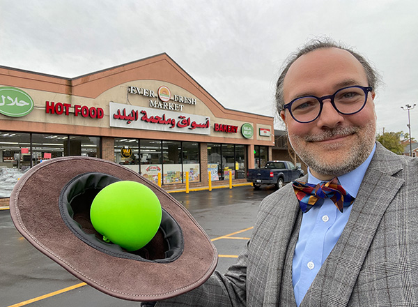 Jesse Mason places a green balloon symbolizing Saturn in his hat on Evergreen Road. His hat symbolizes Saturn's rings. 
