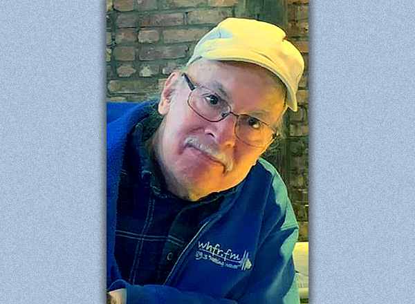 A closeup of Bob wearing a yellow baseball cap and a blue WHFR.FM jacket.
