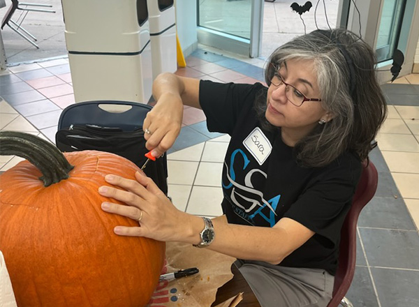 HFC Admissions Associate III Sara Gonzalez-Herrera carves her pumpkin with meticulous detail. 