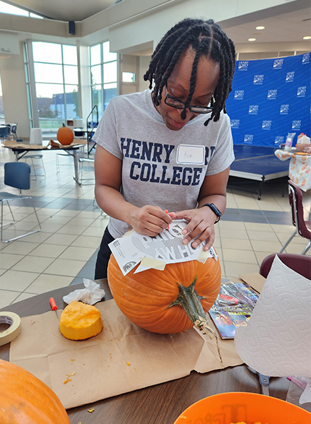 HFC Record Associate II Kimyette Black works diligently on her pumpkin.