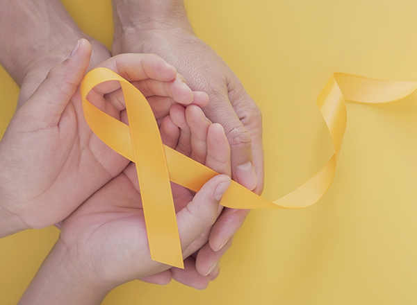 Hands cupped, holding a yellow ribbon folded to support suicide prevention