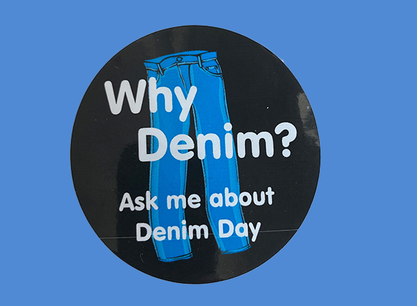 Denim Day sticker that has an illustrated pair of jeans and it reads, “Why Denim? Ask me about Denim Day”