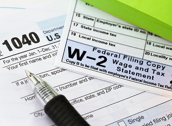 Close up of W-2 and 1040 paperwork and pen.