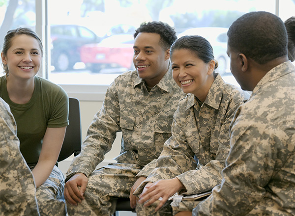 A small group of military wearing camouflage, conversing.