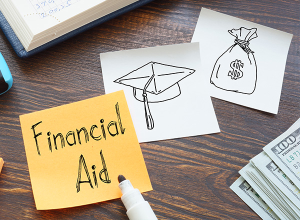 Financial Aid written on a post-it note with other notes illustrated graduation hats and money bag.