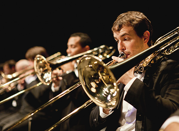 Image of trombone players at an orchestra concert.