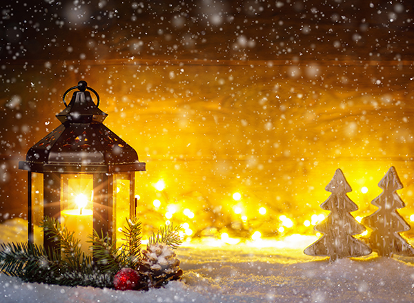 Lighted candle holder, lights, trees evoking a sacred holiday scene
