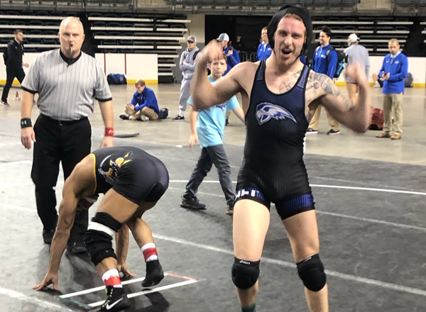 Dominic Mancina holds his arms in victory formation after winning a match