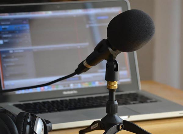 An image of a podcasting setup, a microphone and laptop. 
