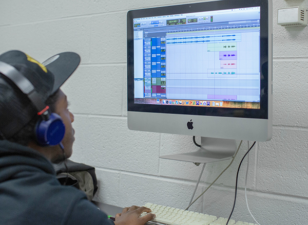 Student with headphones using a specialized computer program