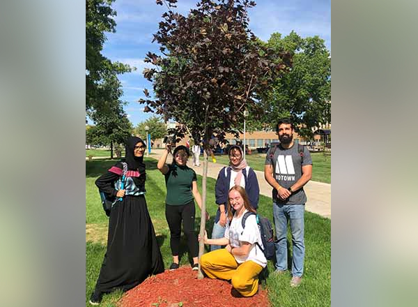 HFC students gather with the tree they planted in 2019. 