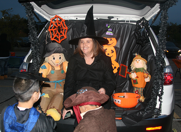 HFC Assistant Director of Financial Aid Stephanie Latzke hands out treats to youngsters at the 2018 Trunk or Treat event.