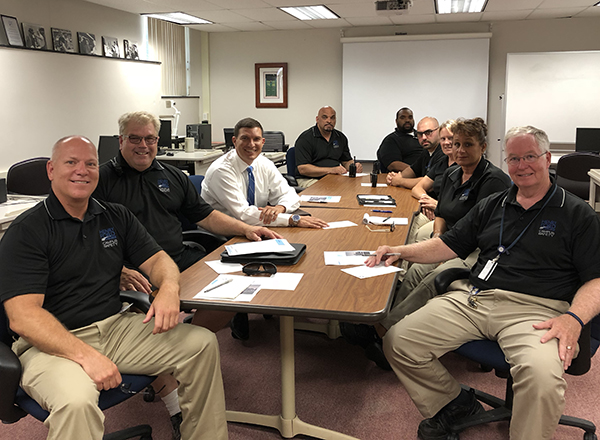 People around a table, wearing HFC polo shirts