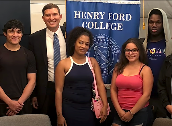 Russ Kavalhuna with students and an HFC banner