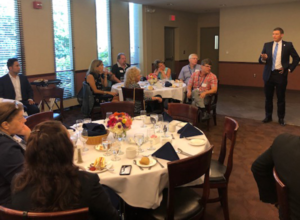 President Kavalhuna stands and addresses seated group at a luncheon.