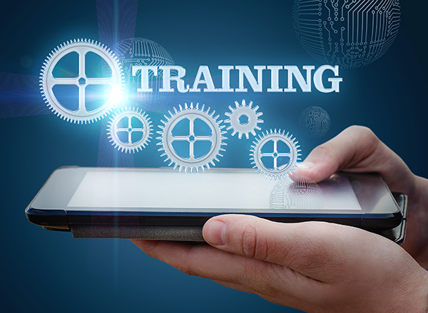 Hands holding a computer tablet face-up, with the word TRAINING and some holographic gears above the tablet