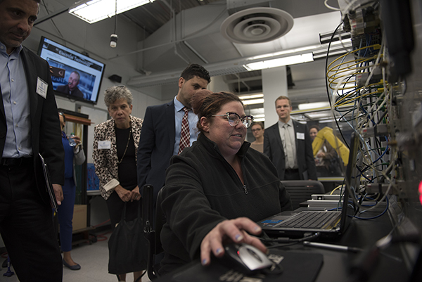 A student demonstrates electrical technology for the day's guests.