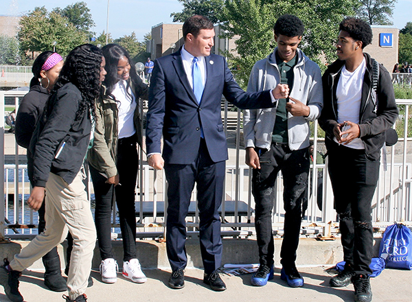 A group of people, two share a fist bump