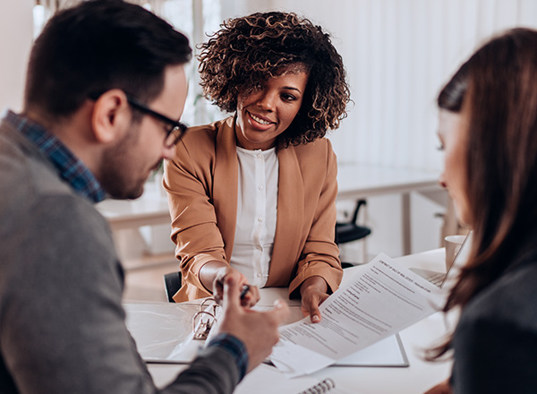 Three people sitting at a table talking.