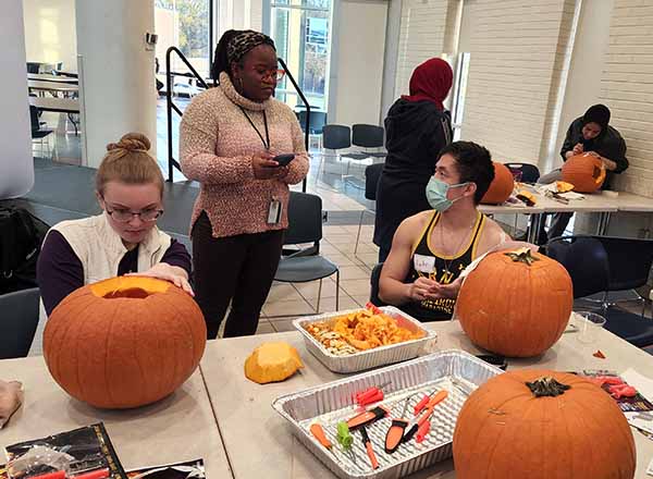 International Admissions Associate Sulian Larmond (standing) watches over Andrea Gartner (left) and Luke Li (right). 
