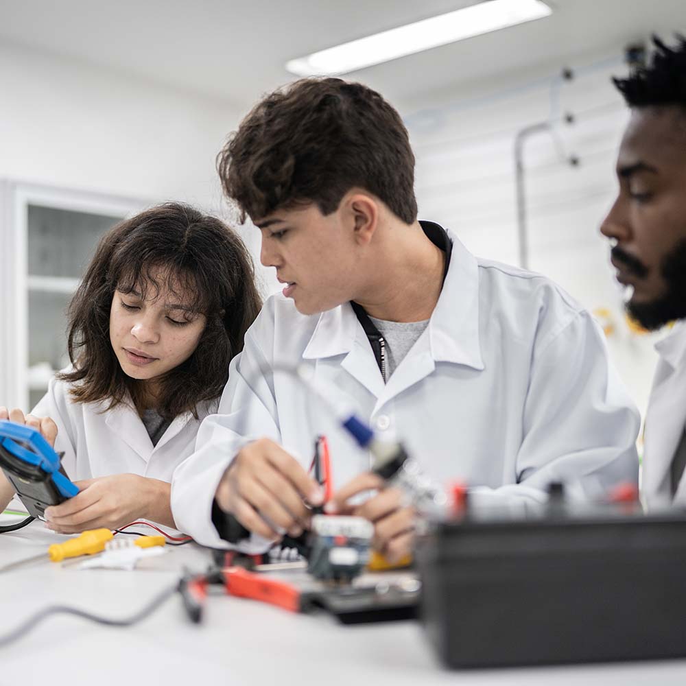 Students at electronics laboratory using measuring equipment