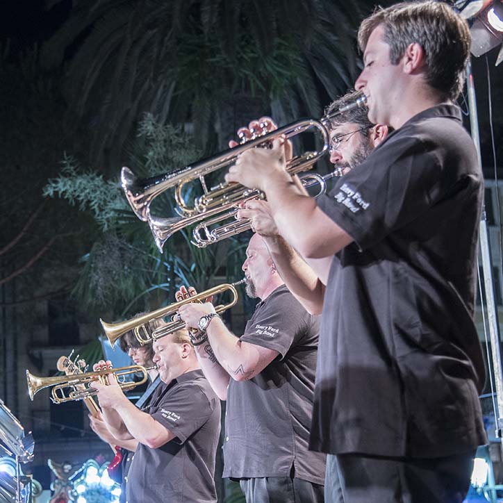 HFC Big Band ensemble members playing trumpets outdoors at night