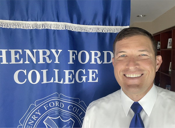 President Kavalhuna in front of an HFC banner