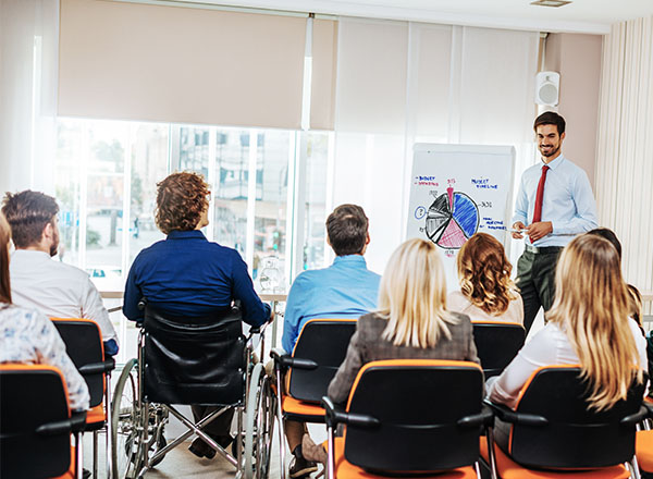 A student leads a presentation to a group of people.
