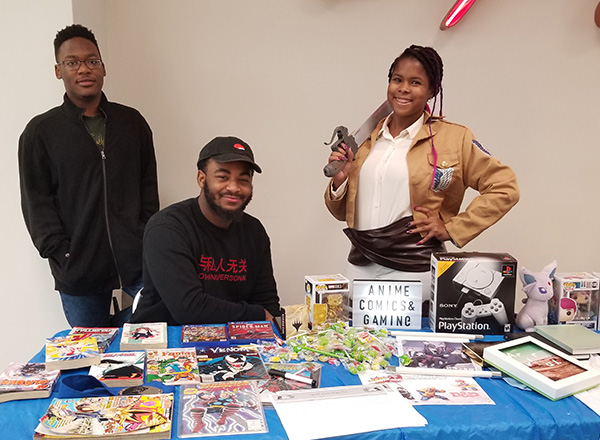 Three people behind a resource table.