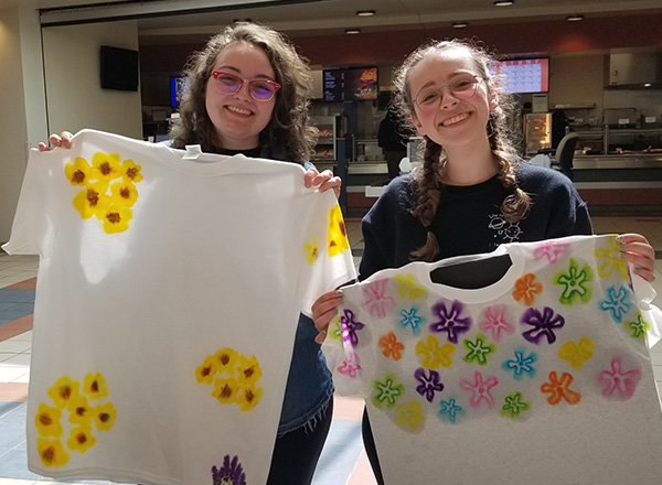 Two HFC students show off their tie-dye T-shirt creations.