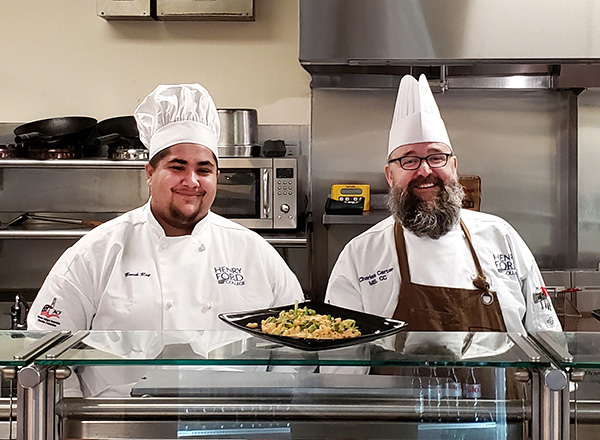 Two chefs at the Wellness Cafe counter.