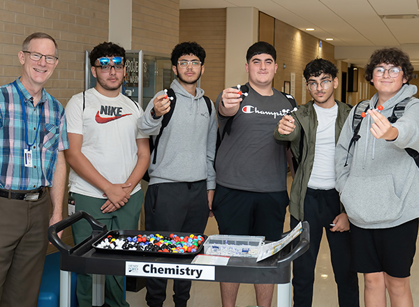 Students gather around the chemistry table.