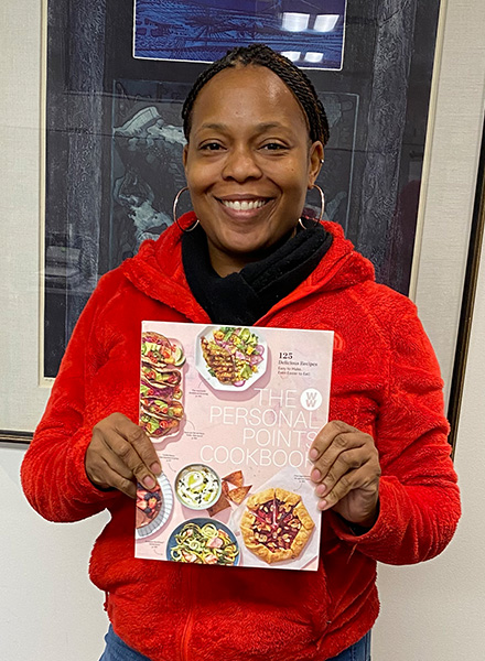 Taryn Ross holds up her prize, "The Weight Watchers Personal Points Cookbook."