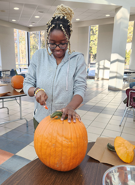 HFC student Lindizga Mkangama has fun carving her jack o'lantern. 